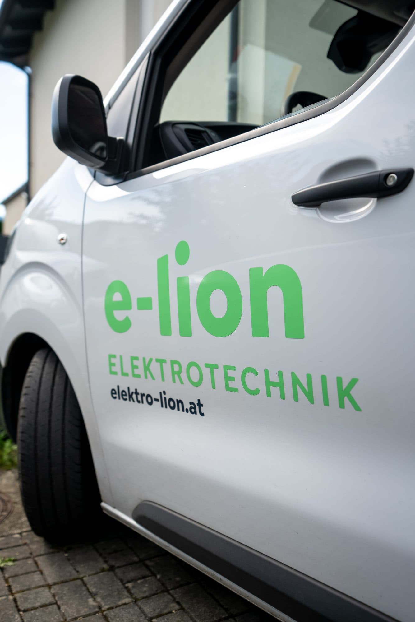 Nahaufnahme der e-lion Firmenbeschriftung auf einem Servicefahrzeug Nahaufnahme der e-lion Firmenbeschriftung auf einem Servicefahrzeug